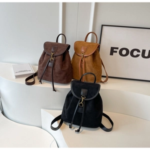 Detail of vintage drawstring backpacks in brown, yellow, and black matte faux suede