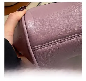 Close-up of precision double stitching on purple lychee pattern leather shell bag