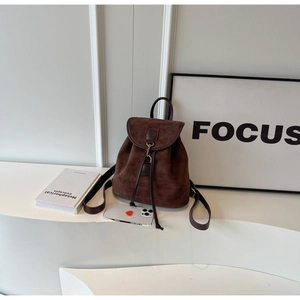 Detail of dark brown vintage faux suede backpack with flap and drawstring closure