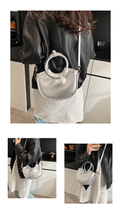 Sac demi-lune argenté moderne avec poignée ronde et bandoulière porté par un mannequin