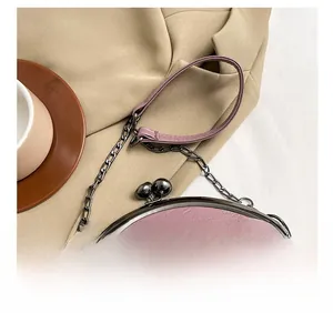 Detail of retro purple shell bag featuring vintage bronze chain and leather strap