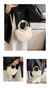 Détail du sac demi-lune beige minimaliste avec poignée ronde et bandoulière argentée