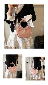 Détail du sac demi-lune rose avec une poignée ronde et une bandoulière réglable