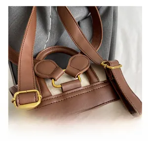 Détail de sangles en cuir marron avec coutures renforcées et boucles en métal doré