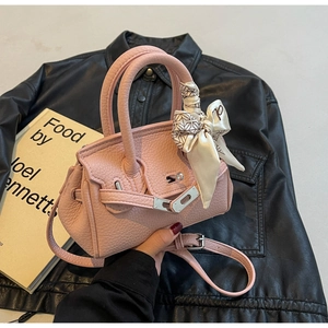 Detail der rosa Lederhandtasche mit Silberverschluss und geometrischem Seidenschal-Griff