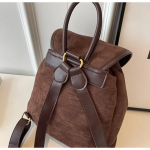 Close-up of brown suede backpack with leather straps and golden metal hardware details