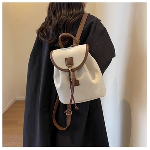 Détail latéral d'un sac à dos femme tendance en toile crème et finitions cuir marron