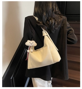 Detail of off-white lychee leather tote bag with knotted strap and cloud charm detail