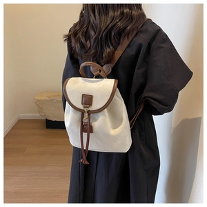 Détail d'un sac à dos vintage en toile beige et cuir avec fermeture à cordon