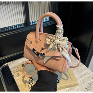 Nahaufnahme der rosa Lederhandtasche mit bedrucktem Seidenschal und silbernem Verschluss