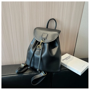 Close-up of black matte faux leather backpack featuring gold metal hook and drawstring closure