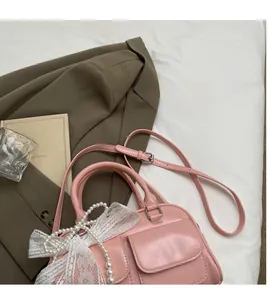 Detail of pink vintage bowling bag featuring white lace bows and pearl charms