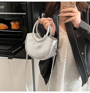 Vue détaillée d'un sac à main argenté en forme de croissant avec bandoulière