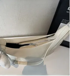 Close-up of smooth silver metal zipper on cream beige lychee pattern tote bag