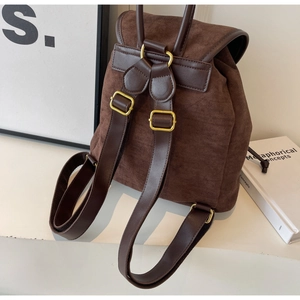 Detail view of dark brown frosted leather backpack with gold metal buckles and straps