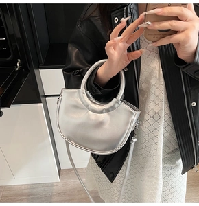 Sac à main croissant argenté au fini métallique présenté lors d'un selfie miroir de style