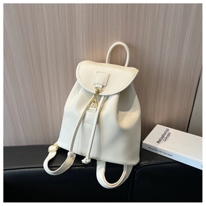 Detail view of cream leather backpack with drawstring closure and gold metal lock