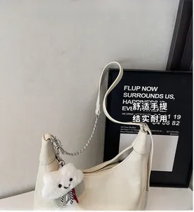 Detail of off-white lychee pattern tote bag with metal chain and plush cloud charm