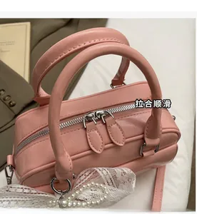 Detail of pink leather Boston bag featuring smooth silver zipper and lace pearl charm