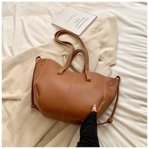 Détail du sac cabas marron à grain de litchi avec surpiqûres blanches contrastées