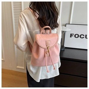 Détail d'un sac à dos en daim rose pâle avec boucle en métal et cordon de serrage