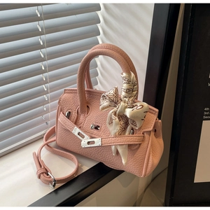 Detailansicht der rosa Lederhandtasche mit Seidenschal und Metallschloss-Verschluss