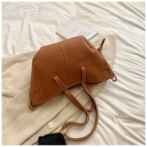 Détail du sac cabas en cuir grainé caramel avec surpiqûres blanches et style minimaliste