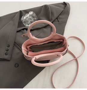 Vue détaillée du sac rose avec compartiment zippé interne et bandoulière longue