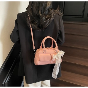 Pink Boston bag with large lace pearl bow detail on a model in black blazer