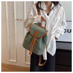 Détail d'un sac à dos en daim vert foncé avec garniture en cuir et boucle métallique