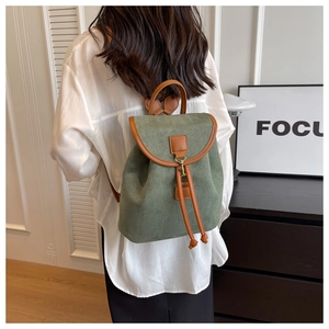Vue détaillée de dos d'un sac à dos vintage vert foncé avec finitions en cuir marron