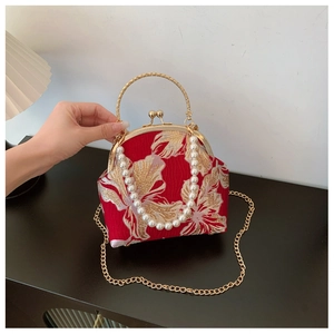 Macro detail of red silk embroidery and pearl handle on vintage cheongsam handbag