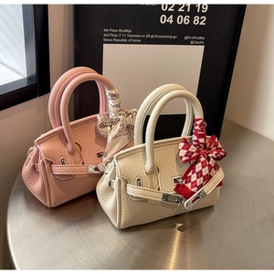 Detail von Mini-Lederhandtaschen in Rosa und Weiß mit Seidenschals an den Griffen