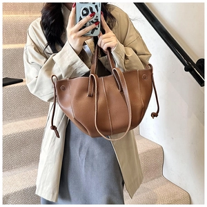 Détails des surpiqûres contrastées et du cuir grainé sur un sac cabas marron