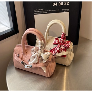 Details von Mini-Lederhandtaschen mit bedruckten Seidenschals und Metallschnallen