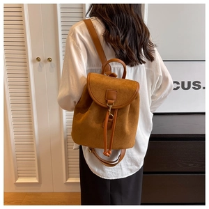 Sac à dos minimaliste en daim camel avec rabat et cordon de serrage dans un décor moderne
