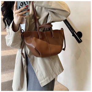 Détail du sac cabas marron foncé avec texture litchi, coutures contrastées et nœud décoratif