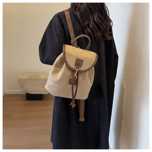 Vue arrière d'un sac à dos vintage en daim beige avec lanières en cuir marron et boucle