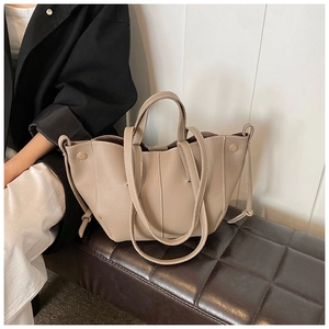 Détail du sac cabas en similicuir à motif litchi avec coutures blanches et boucle dorée