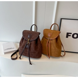 Detail view of suede drawstring backpacks in vintage brown and caramel colors