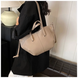 Sac fourre-tout gris en cuir grainé avec coutures contrastées posé sur un banc chic