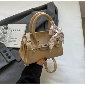 Detailansicht der beigen Ledertasche mit dekorativem rosa Herz-Blumenschal am Griff