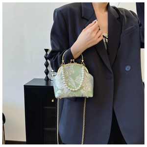 Detail of vintage mint green floral jacquard handbag with pearl handle and gold chain