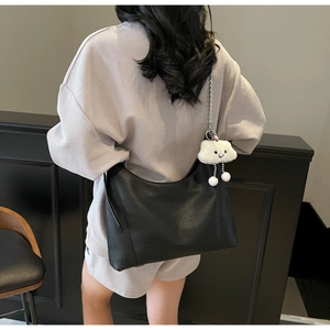 Detail of black pebbled leather tote bag with silver chain strap and cloud charm