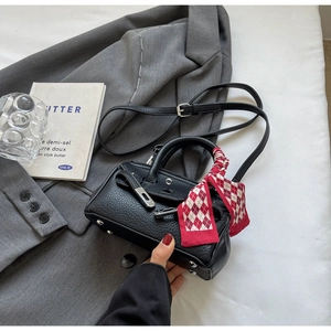 Detail der Lederhandtasche mit Lychee-Muster, kariertem Seidentuch und silbernem Schloss
