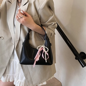 Sac à main minimaliste en cuir noir mat avec ruban rose et breloque nœud en perles
