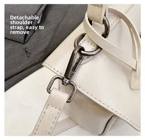 Detail of the high-quality detachable shoulder strap hardware on the off-white leather bag