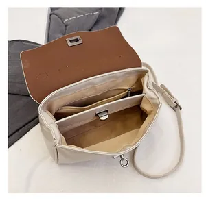 Detailed interior view of a cream shoulder bag featuring multiple compartments and zip pocket