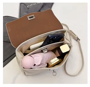 Interior view of off-white crossbody bag showing large capacity and zipper pocket