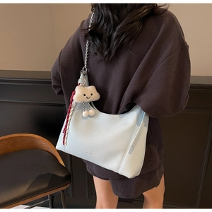 Detail of light blue lychee pattern hobo bag with cloud charm and chain strap detail